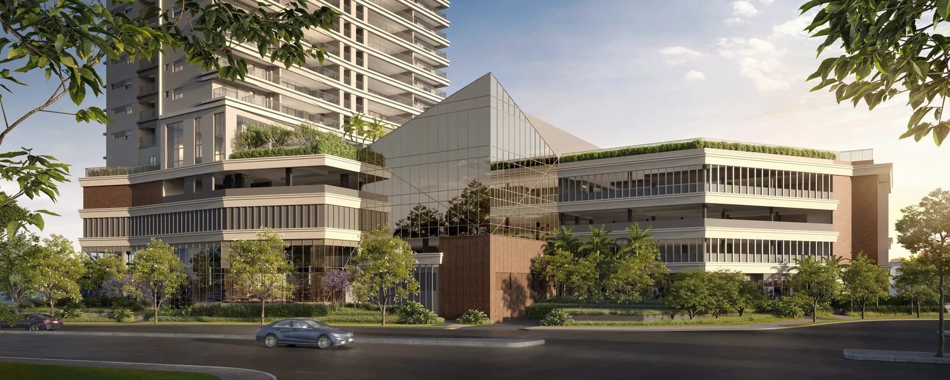 Fachada do edifício com estrutura moderna, vidraças e paisagismo no entorno.