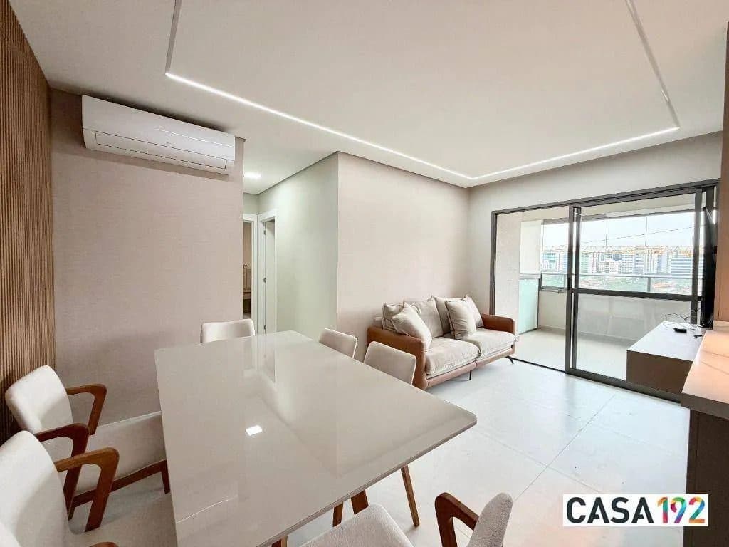Sala de estar e jantar integrada com ar-condicionado, mesa de jantar e sofá.