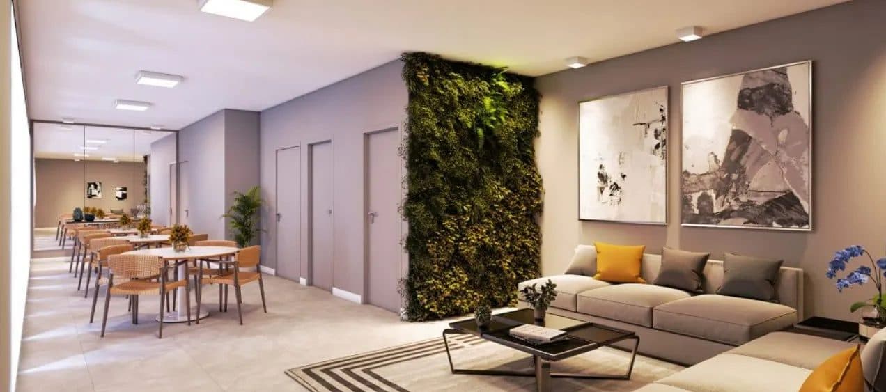 Sala de estar com sofá bege, quadros na parede e jardim vertical artificial.