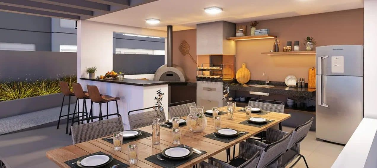 Área gourmet coberta com churrasqueira, forno de pizza, mesa de jantar e bancada com banquetas.